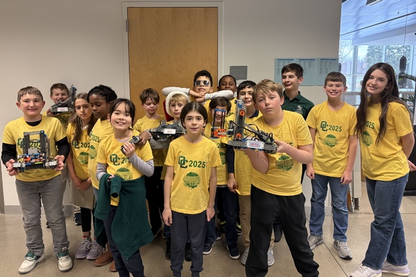 The 4th&ndash;6th grade Oakland Christian VEX Robotics team smiling as a a group with their robots.