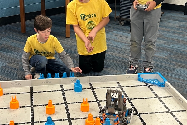Three Oakland Christian students concentrate as they compete with their robot.