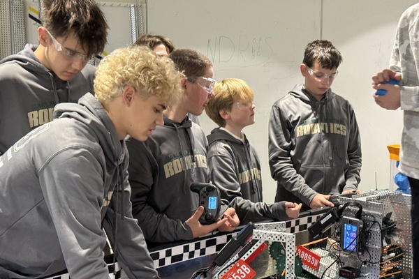 A group of Oakland Christian robotics students works with their robot.