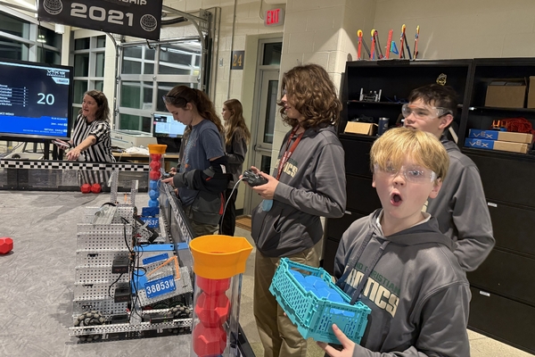 Oakland Christian students work with their robots at a competition.