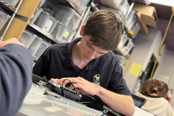 An Oakland Christian student works on an electrical component in class.