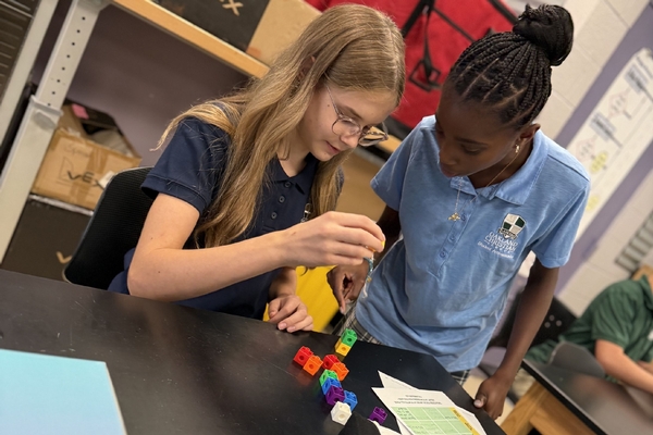 Two Oakland Christian girls collaborate on a building project.