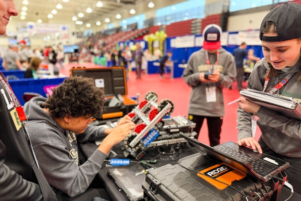 Oakland Christian students work on their VEX robot at a competition.