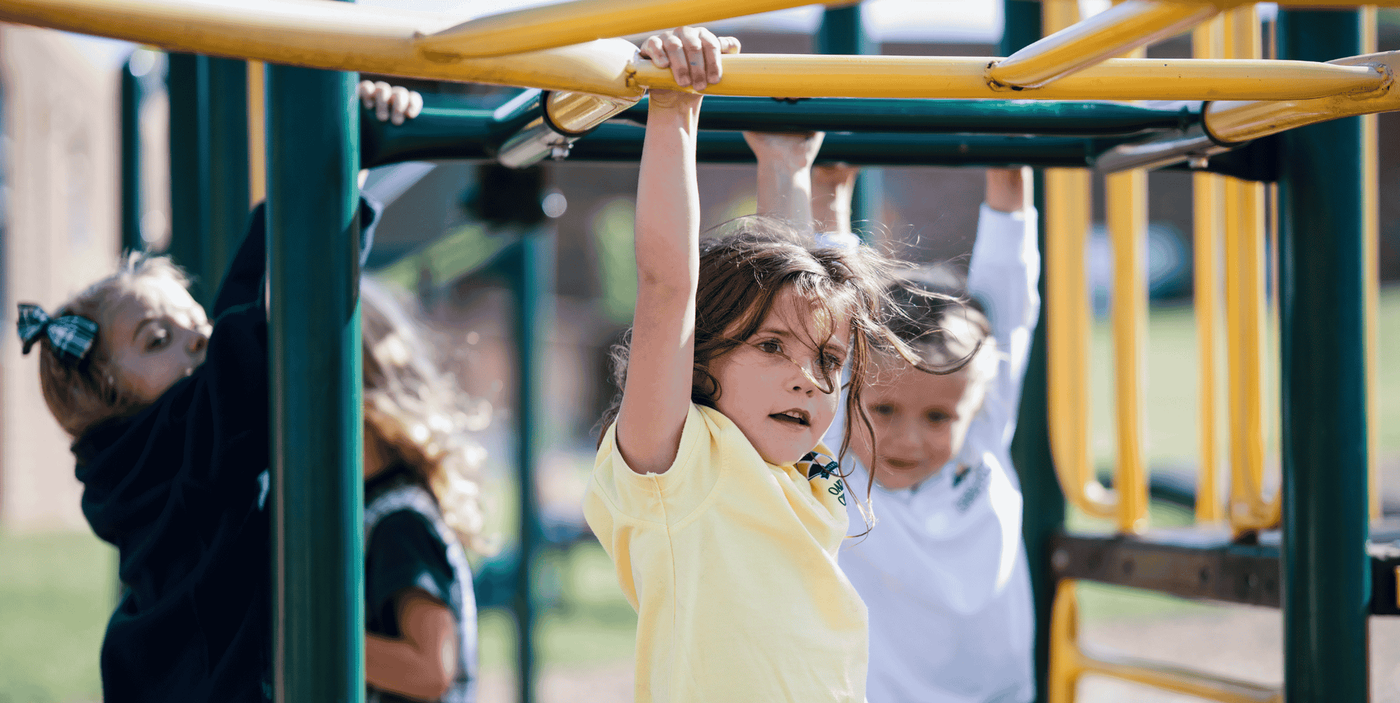 Elementary girls enjoy playing on the monkey bars